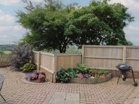 A garden with flowers and a grill at Rainbow View in Churchstanton near Churchinford
