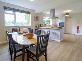 A kitchen and dining area with a table, chairs, stools, and kitchen island at The Wardens House in Tregynon near Newtown