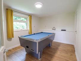 A room with a pool table under a window with yellow curtains at The Wardens House in Tregynon near Newtown