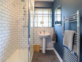 A bathroom with a walk-in shower sink mirror and towel rack at The Wardens House in Tregynon near Newtown