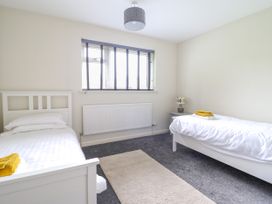 A bedroom with two single beds a window and a bedside table at The Wardens House in Tregynon near Newtown