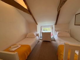A bedroom with two beds and a dresser at Aaron's Cottage in St Teath