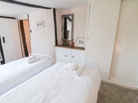 A bedroom with twin beds and a mirror at Rhubarb Cottage Ufford near Woodbridge