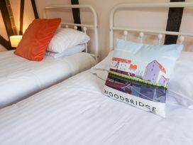 A bedroom with two beds and a decorative pillow at Rhubarb Cottage Ufford near Woodbridge