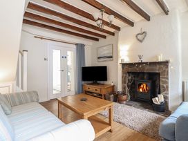 A living room with a fireplace and sofa at Riverside Cottage in Beddgelert