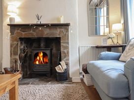 A living room with a fireplace and sofa at Riverside Cottage in Beddgelert