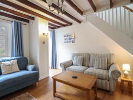 A living room with sofas and a coffee table at Riverside Cottage in Beddgelert