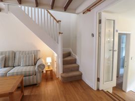 A living room with a sofa and stairs at Riverside Cottage in Beddgelert