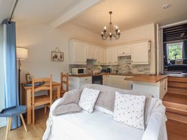 A living room with a kitchen and dining area at Riverside Cottage in Beddgelert