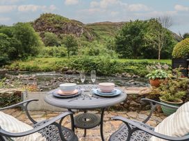 A table set with bowls and glasses near a river at Riverside Cottage in Beddgelert