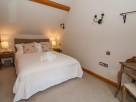 A bedroom with a double bed with pillows and lamps on bedside tables at Servant's Quarters in Bolton Percy near Tadcaster