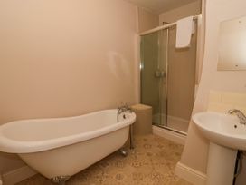A bathroom with a clawfoot bathtub a shower with a glass door a pedestal sink and a laundry basket at Servant's Quarters in Bolton Percy near Tadcaster