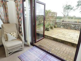 A conservatory with a rocking chair and views of the patio at Penn Lea Penally