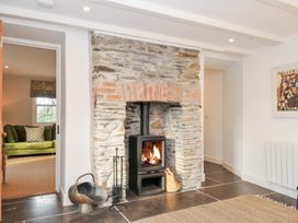 A living room with a stone fireplace and wood stove at Mermaid Cottage in Port Isaac