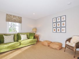 A living room with a green couch and a lamp at Mermaid Cottage in Port Isaac