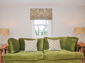 A living room with a green sofa and decorative cushions at Mermaid Cottage in Port Isaac