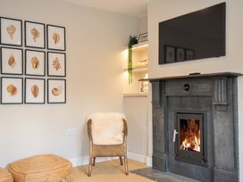 A living room with a fireplace and a television at Mermaid Cottage in Port Isaac