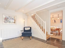 A hallway with a chair and staircase at Mermaid Cottage in Port Isaac