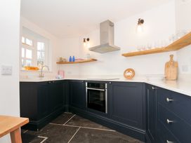 A kitchen with a sink and oven at Mermaid Cottage in Port Isaac