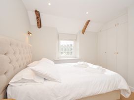 A bedroom with a bed and wardrobe at Mermaid Cottage in Port Isaac