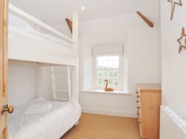 A bedroom with a bunk bed and a single bed at Mermaid Cottage in Port Isaac