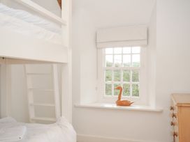 A bedroom with a bunk bed and a window at Mermaid Cottage in Port Isaac