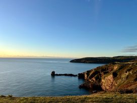 A coastal view with cliffs and the sea under a clear sky at Ingledene in Brixham