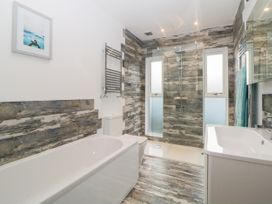 A bathroom with a bathtub toilet shower and sink at Ingledene in Brixham