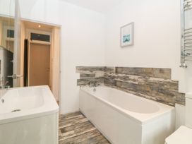 A bathroom with a bathtub sink and toilet at Ingledene in Brixham