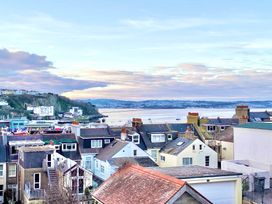 A view of rooftops with boats on water and hills in the background at Ingledene in Brixham