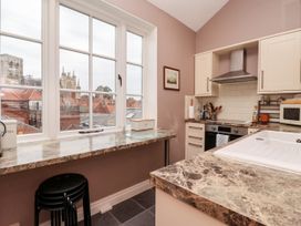 A kitchen with marble countertops a window view of buildings and a cathedral at 6 Granary Court in York