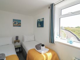 A bedroom with two beds and a window at Sunset Sea View Chalet in Millbrook