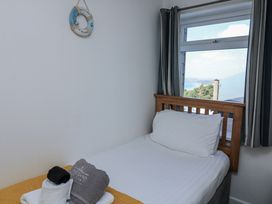 A bedroom with a single bed and towels at Sunset Sea View Chalet in Millbrook