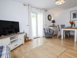 A living room with a television and dining area at Flat 4 in Newquay