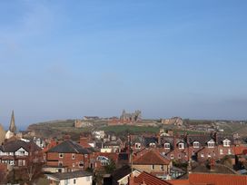 A view of rooftops and castle ruins at Sunset View in Whitby