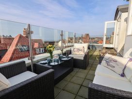 A balcony with an outdoor sofa and coffee table at Sunset View in Whitby