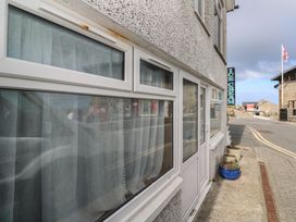A building exterior with windows and an ice cream sign at Harbour Studio in Sennen Cove