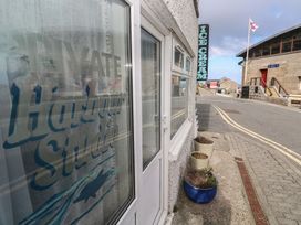 An outdoor view of a sign for Harbour Studio at Sennen Cove