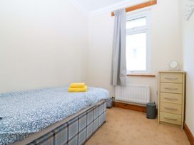 A bedroom with a bed and a drawer unit at Cwm Eilir in Criccieth