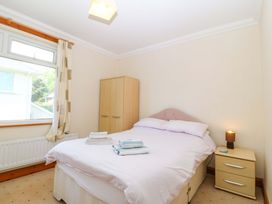 A bedroom with a bed and wardrobe at Cwm Eilir in Criccieth