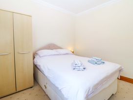 A bedroom with a bed and wardrobe at Cwm Eilir in Criccieth