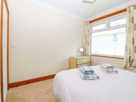 A bedroom with towels on the bed at Cwm Eilir in Criccieth