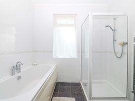 A bathroom with a bathtub and shower at Cwm Eilir in Criccieth