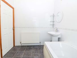 A bathroom with a sink, toilet and bath at Cwm Eilir in Criccieth