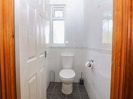 A bathroom with a toilet and window at Cwm Eilir Criccieth