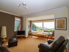 A living room with a sofa and TV at Cwm Eilir in Criccieth