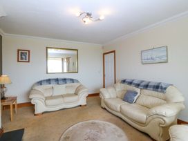 A living room with two sofas and a lamp at Cwm Eilir in Criccieth