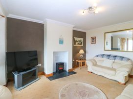 A living room with a television and fireplace at Cwm Eilir in Criccieth