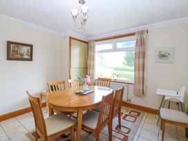 A dining room with a table and chairs at Cwm Eilir in Criccieth