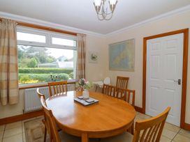 A dining room with a table and chairs at Cwm Eilir in Criccieth